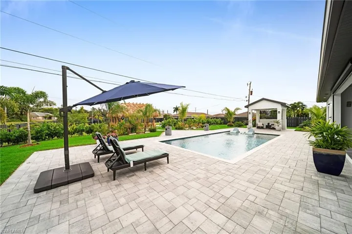 View of pool with a patio and a lawn