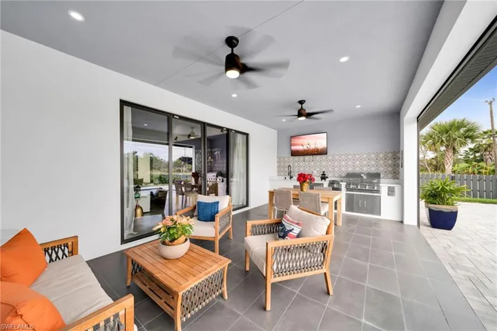 View of terrace featuring grilling area, an outdoor living space, exterior kitchen, and ceiling fan