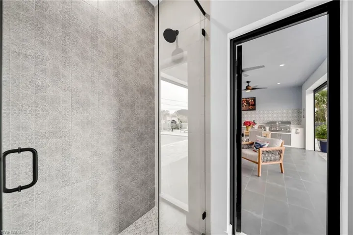Bathroom featuring a shower with shower door, tile flooring, and ceiling fan