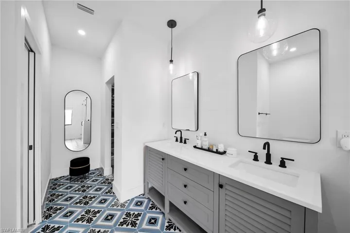 Bathroom featuring tile floors, dual sinks, and large vanity