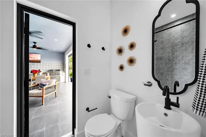 Bathroom with sink, tile flooring, ceiling fan, and toilet