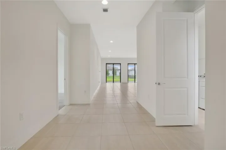 Corridor featuring light tile flooring