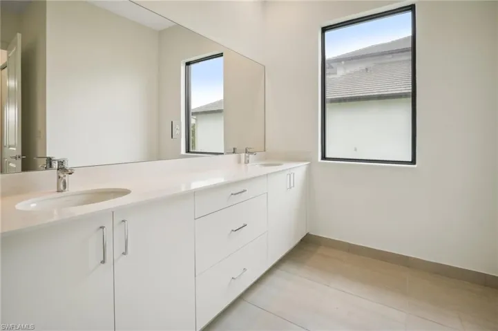 Bathroom featuring double vanity and tile floors