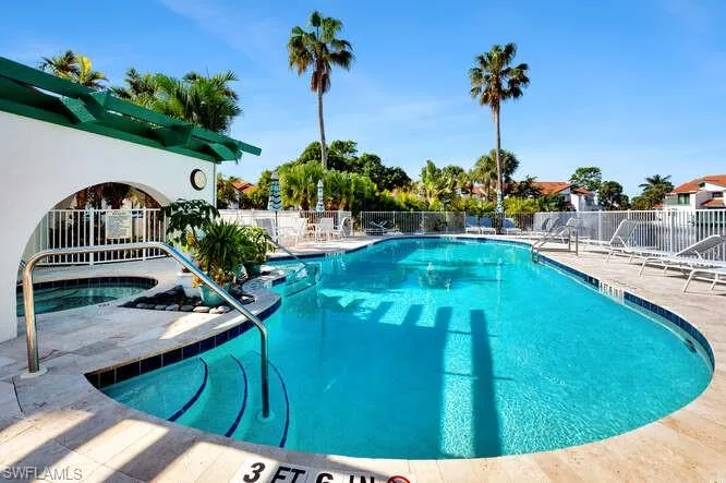 View of swimming pool featuring a patio and a hot tub