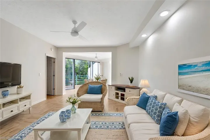Living room with ceiling fan and light parquet floors