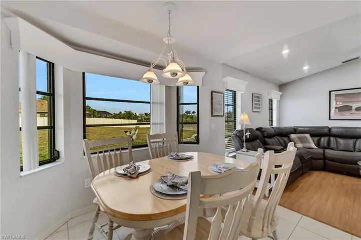 Tiled dining area featuring a wealth of natural light and lofted ceiling