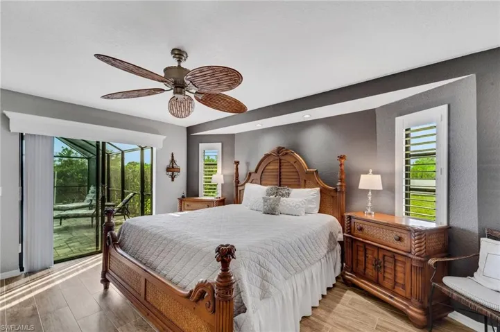 Bedroom featuring multiple windows, hardwood / wood-style flooring, ceiling fan, and access to outside