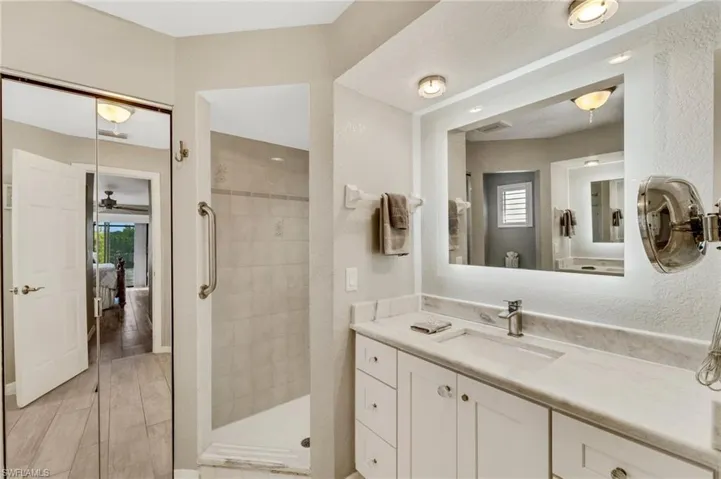 Bathroom with wood-type flooring, walk in shower, plenty of natural light, and vanity