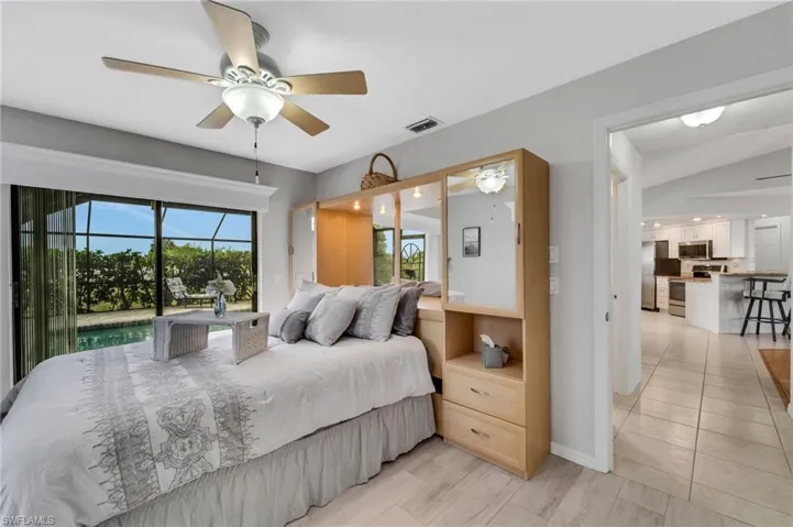 Tiled bedroom featuring ceiling fan and lofted ceiling