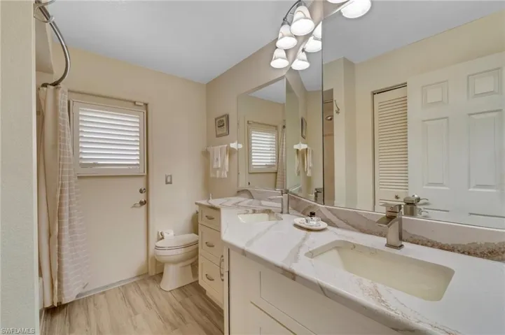 Bathroom featuring hardwood / wood-style floors, toilet, and vanity
