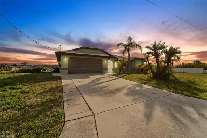 Ranch-style home with a garage and a lawn