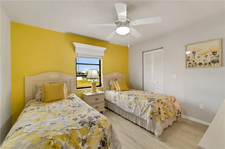 Bedroom with a closet, ceiling fan, and light hardwood / wood-style flooring