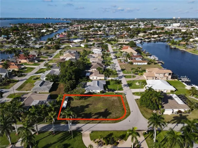 Aerial view of residential area with property boundaries highlighted and a large body of water