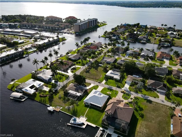 Aerial view of property and surrounding area with a nearby body of water and nearby suburban area