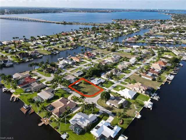 Aerial view of property's location with a large body of water, nearby suburban area, and property boundaries highlighted
