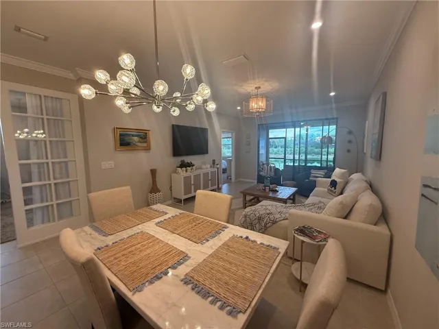 Open-concept living space with tile flooring, crown molding, and recessed lighting