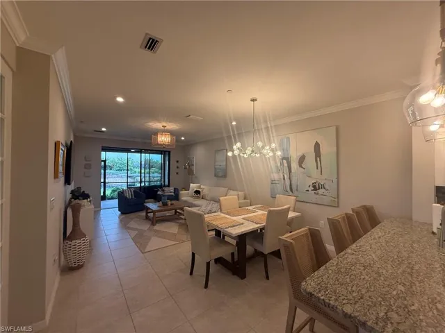 Open-concept living area with tile flooring and crown molding