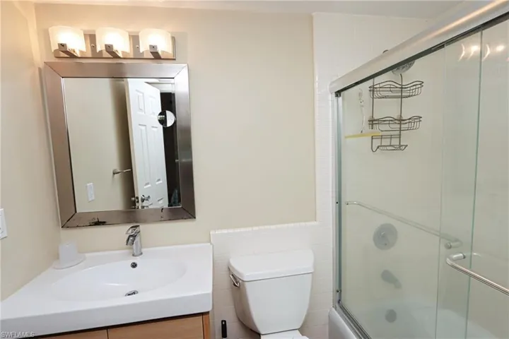 Bathroom with vanity, tile walls, and toilet