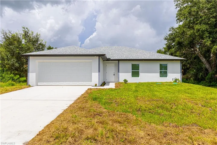 View of front facade featuring a garage and a front yard
