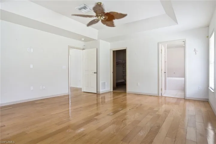 Spacious primary suite complete with a nature view window nook, large walk-in closet, and an ensuite bath with a soaking tub and glass-enclosed shower