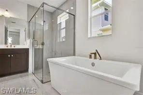 Primary bathroom with luxe walk-in shower and freestanding Kohler soaking tub