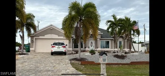 Ranch-style home featuring decorative driveway, a garage, and stucco siding