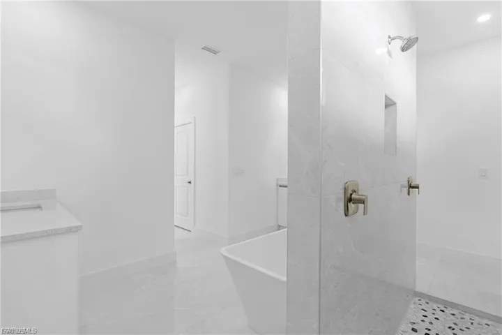 Full bathroom with vanity, a marble finish shower, and a soaking tub