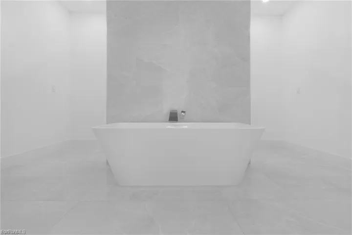 Full bath featuring a freestanding bath and tile walls