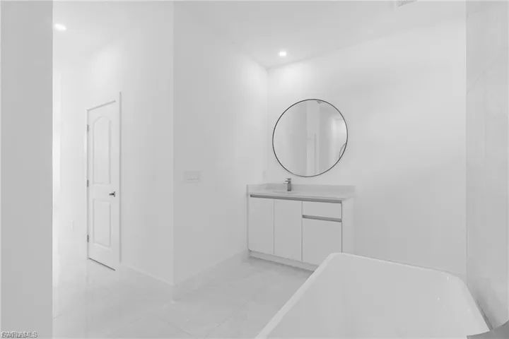 Full bathroom with vanity, a freestanding bath, and recessed lighting