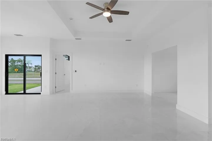 Empty room featuring a raised ceiling and ceiling fan