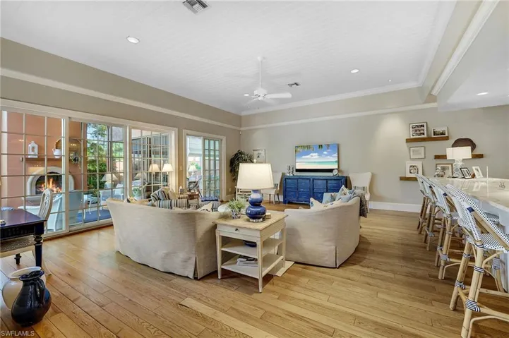 Living room with crown molding, ceiling fan, and light hardwood / wood-style flooring