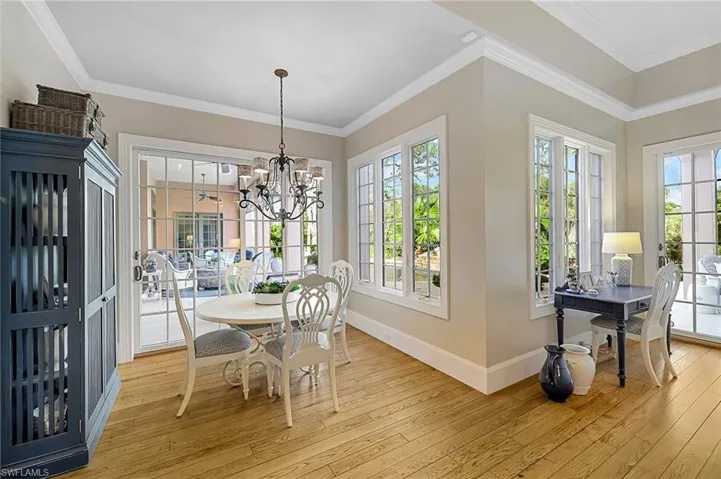 Dining space featuring ornamental molding, light hardwood / wood-style floors, and a notable chandelier