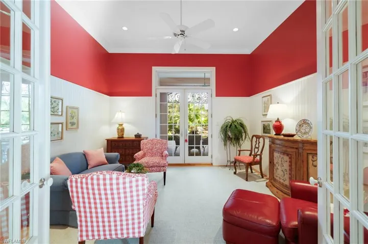 Living area with ceiling fan, crown molding, light carpet, and french doors