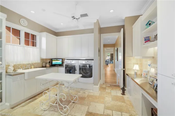 Laundry area featuring separate washer and dryer, a healthy amount of sunlight, sink, and ornamental molding