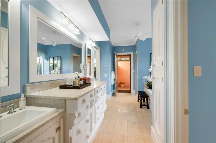 Bathroom with ornamental molding, vanity, and tile patterned floors