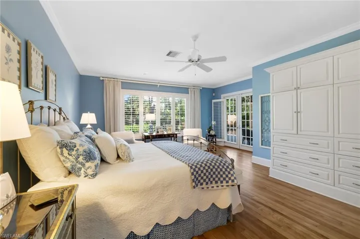 Bedroom featuring ceiling fan, dark hardwood / wood-style floors, crown molding, french doors, and access to outside