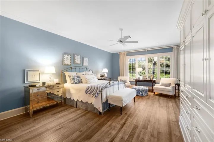 Bedroom featuring ornamental molding, hardwood / wood-style flooring, and ceiling fan