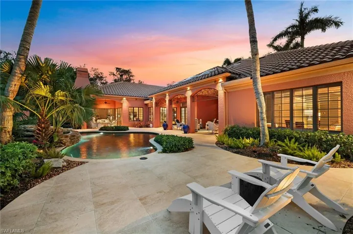Pool at dusk featuring a patio