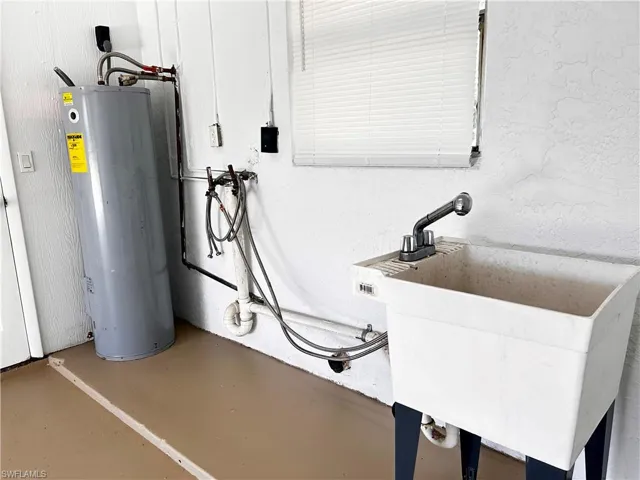 Utility room with water heater and a sink