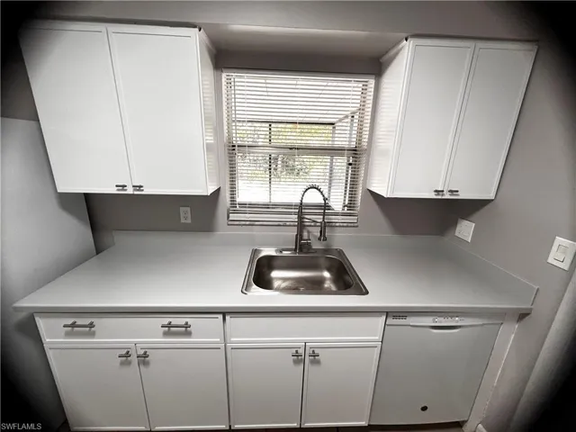 Kitchen featuring white cabinetry, light countertops, and dishwasher
