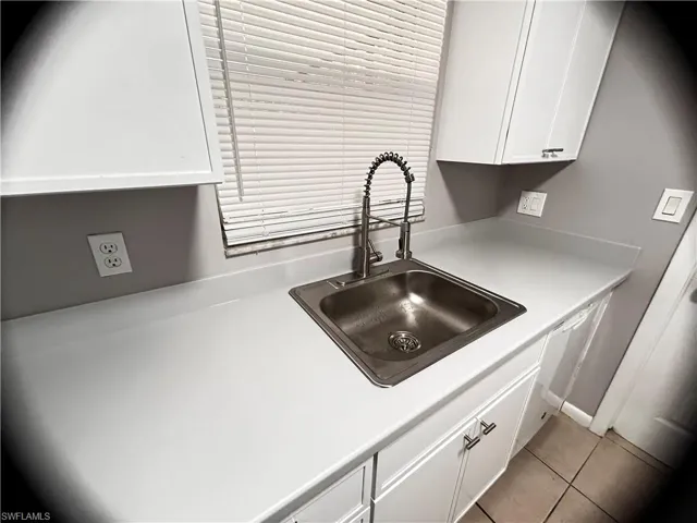 Kitchen view of white cabinetry and light countertops