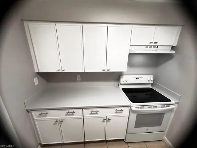 Kitchen featuring white cabinetry, white electric range, and light countertops