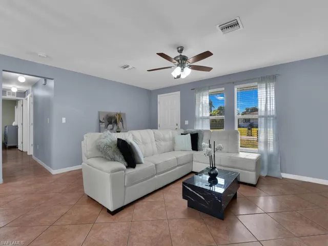 Living area with a ceiling fan and light tile patterned floors