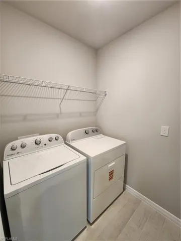 Laundry room with baseboards and washing machine and dryer