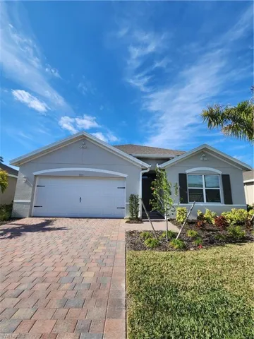 Ranch-style home featuring stucco siding, decorative driveway, and a garage