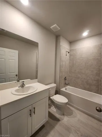 Bathroom featuring bathtub / shower combination, vanity, and recessed lighting