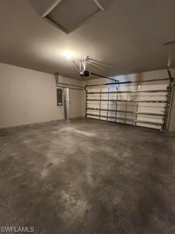 Garage featuring concrete block wall and electric panel