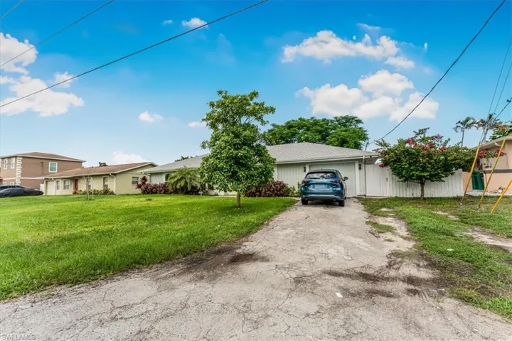View of front of house with an attached garage, driveway, and a front yard