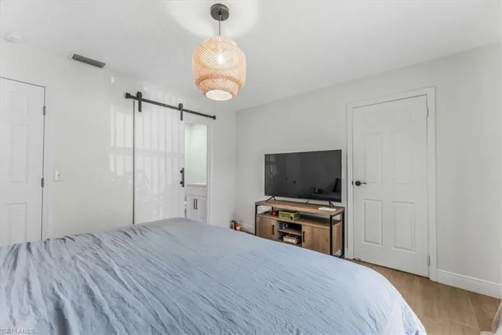 Bedroom featuring a barn door and wood finished floors