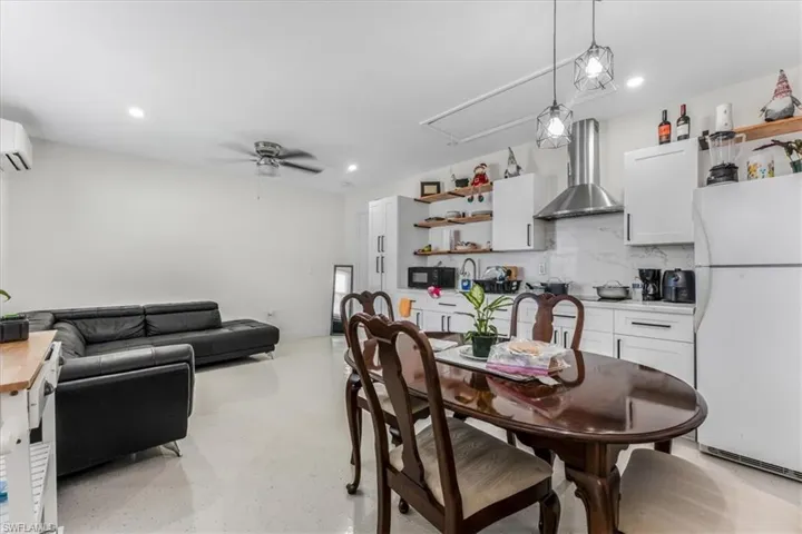 Dining area featuring attic access, a ceiling fan, recessed lighting, concrete floors, and a wall mounted AC